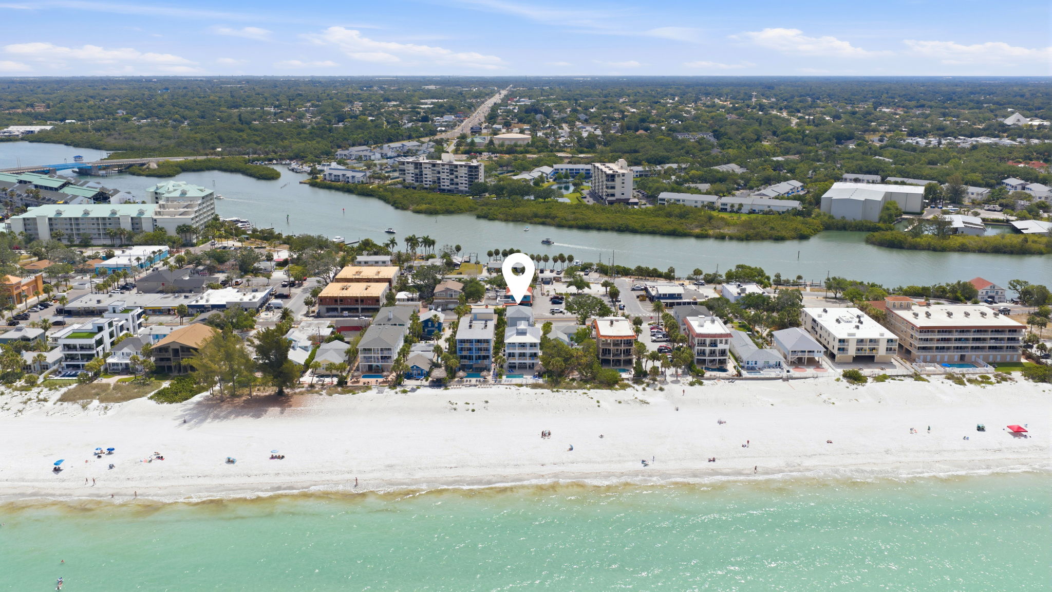 Aerial view from Gulf of Mexico over Indian Rocks Beach Florida showing white sand beach beachfront STR investment properties condos and vacation rental homes along Gulf Boulevard with Intracoastal Waterway visible behind - illustrates the micro-location difference between Gulf-front and non-Gulf-front short-term rental investment properties in Pinellas County