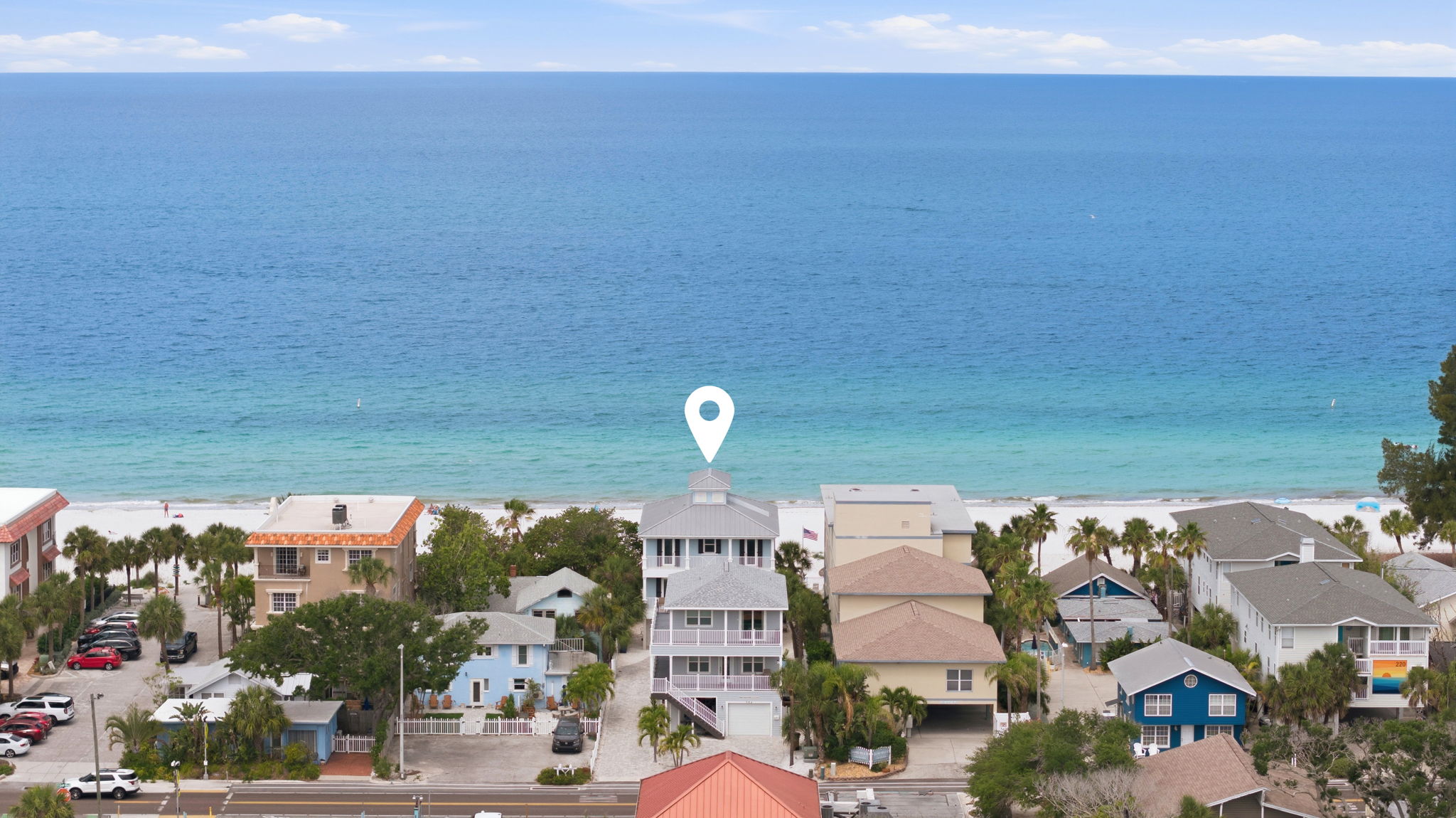 Gulf-side short-term rental investment property in Indian Rocks Beach Florida with direct Gulf of Mexico beach access showing white sand beach emerald water and coastal homes - Gulf Boulevard STR properties command premium nightly rates in the Pinellas County vacation rental market