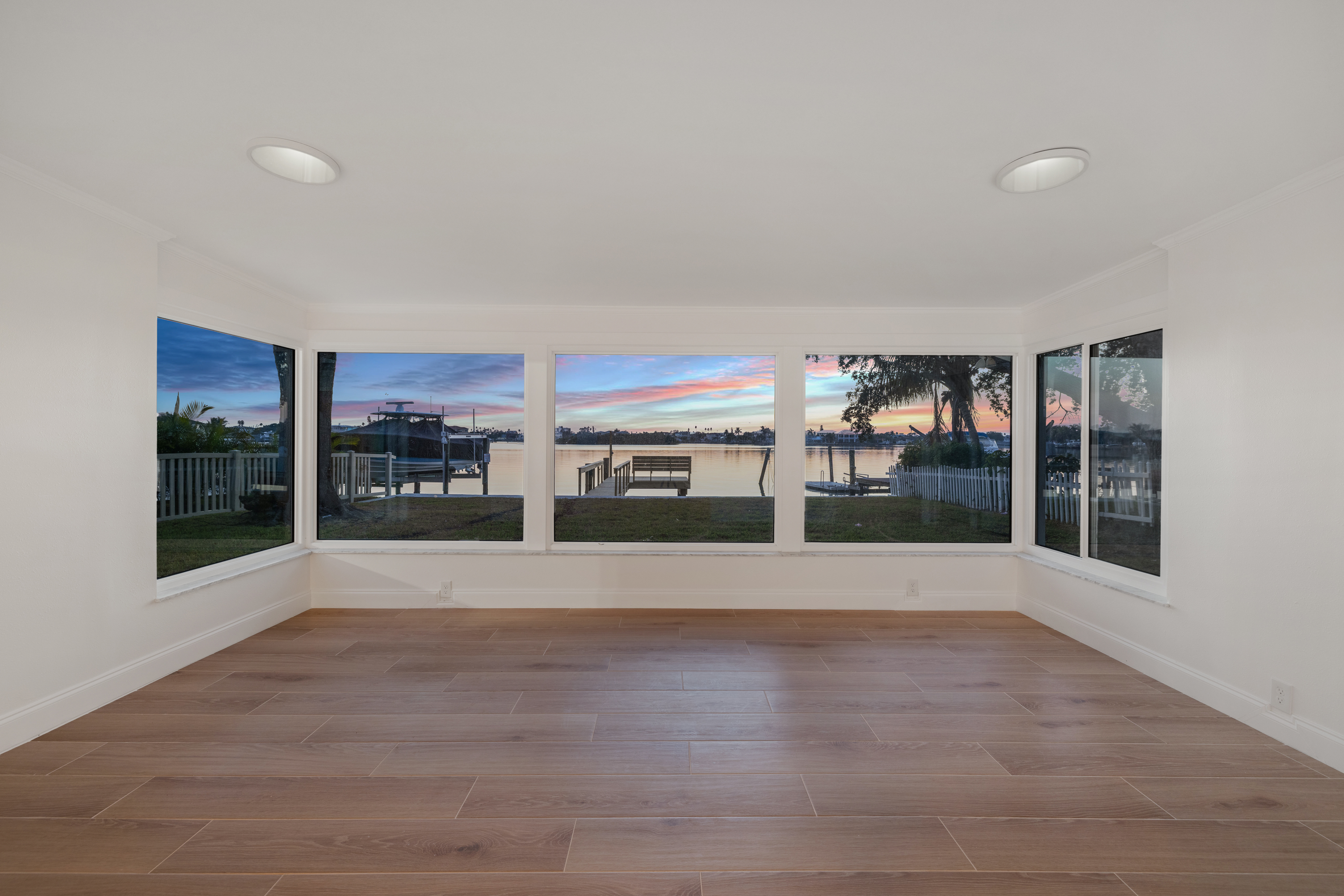 Interior room with floor to ceiling windows showing Intracoastal Waterway sunset view from short-term rental investment property in Indian Rocks Beach Florida - panoramic water views create premium guest experience driving higher nightly rates and occupancy