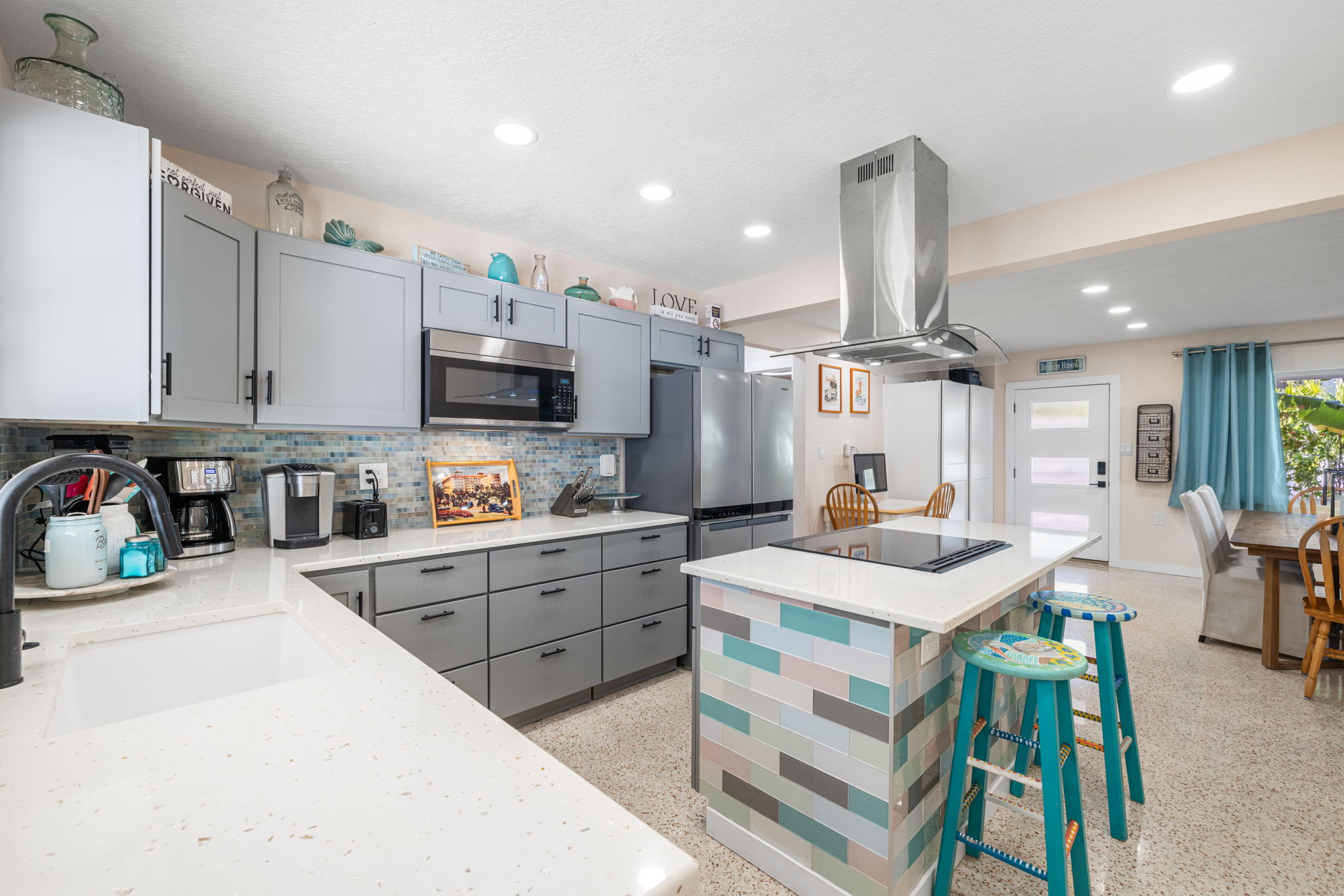 Fully renovated turnkey kitchen in Indian Rocks Beach short-term rental investment property featuring quartz countertops stainless appliances kitchen island and coastal decor - turnkey kitchen quality drives five star guest reviews and repeat bookings in the Pinellas Gulf Beach vacation rental market