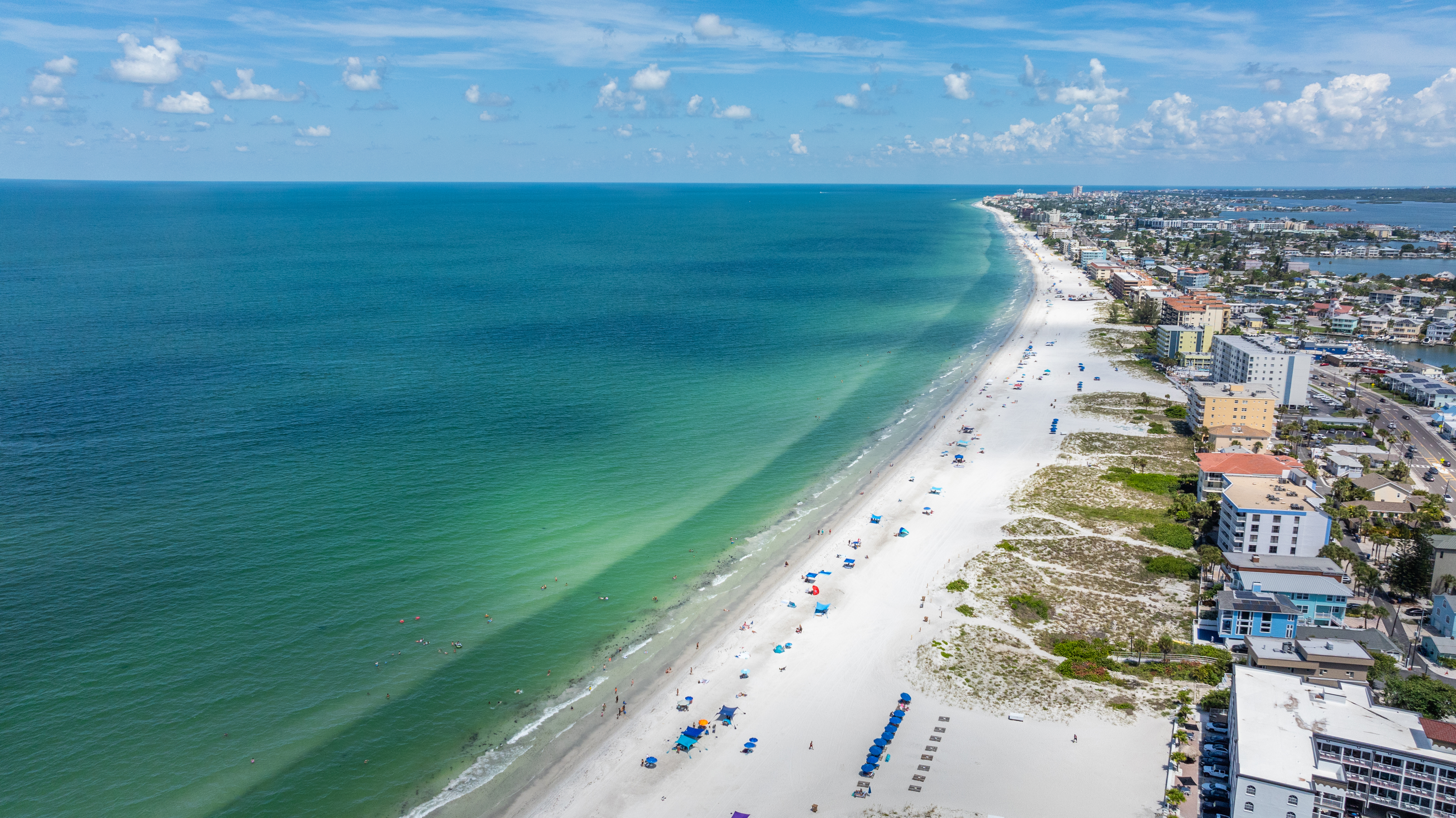 Aerial view of Madeira Beach Gulf Boulevard STR condo corridor with white sand beach and Gulf of Mexico - short-term rental investment properties along the Pinellas County Florida Gulf Beaches