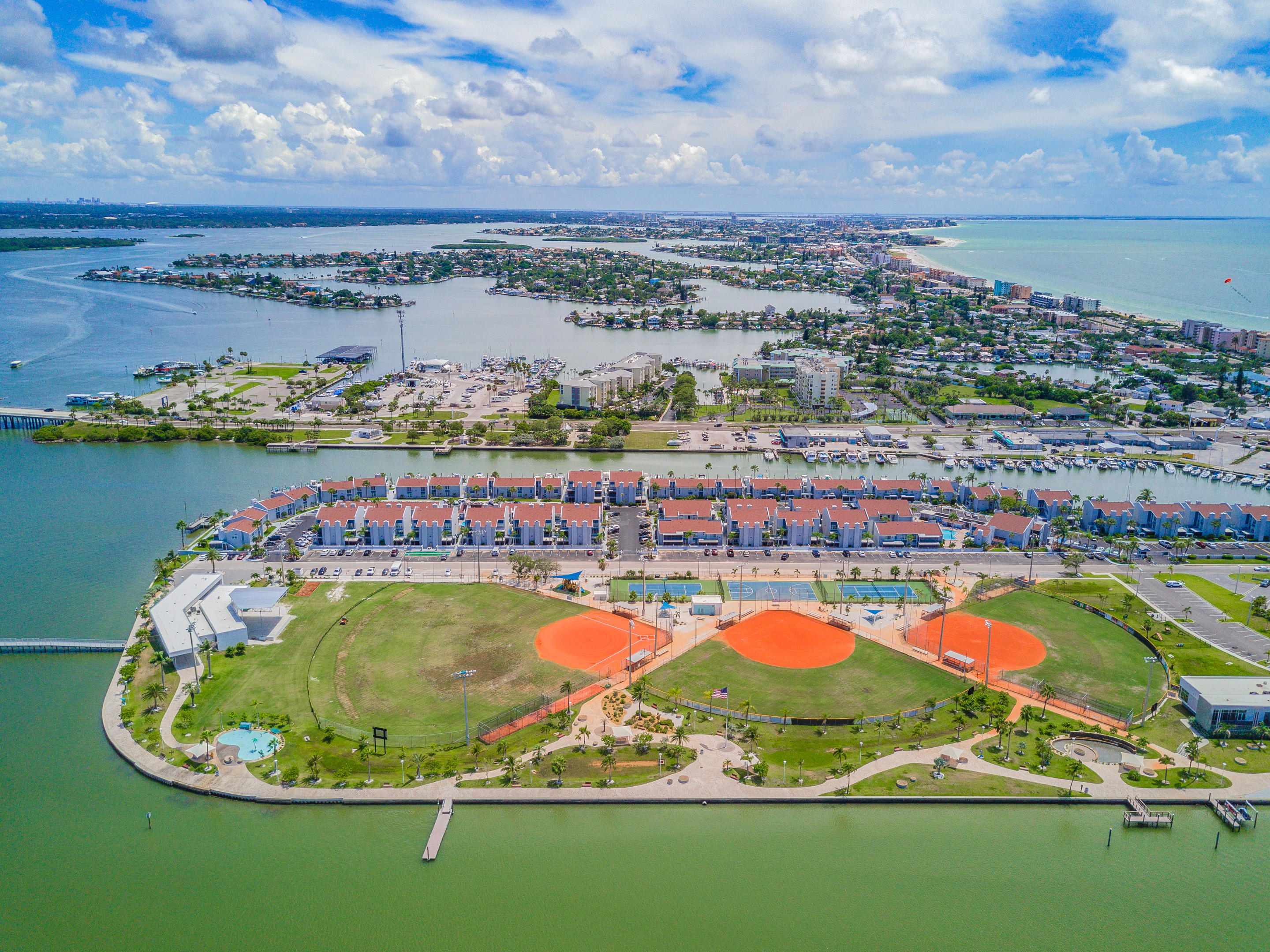 Aerial view of R.O.C. Park softball and baseball fields with Madeira Beach Yacht Club condos in background Madeira Beach Florida - tournament events drive short-term rental demand Pinellas County