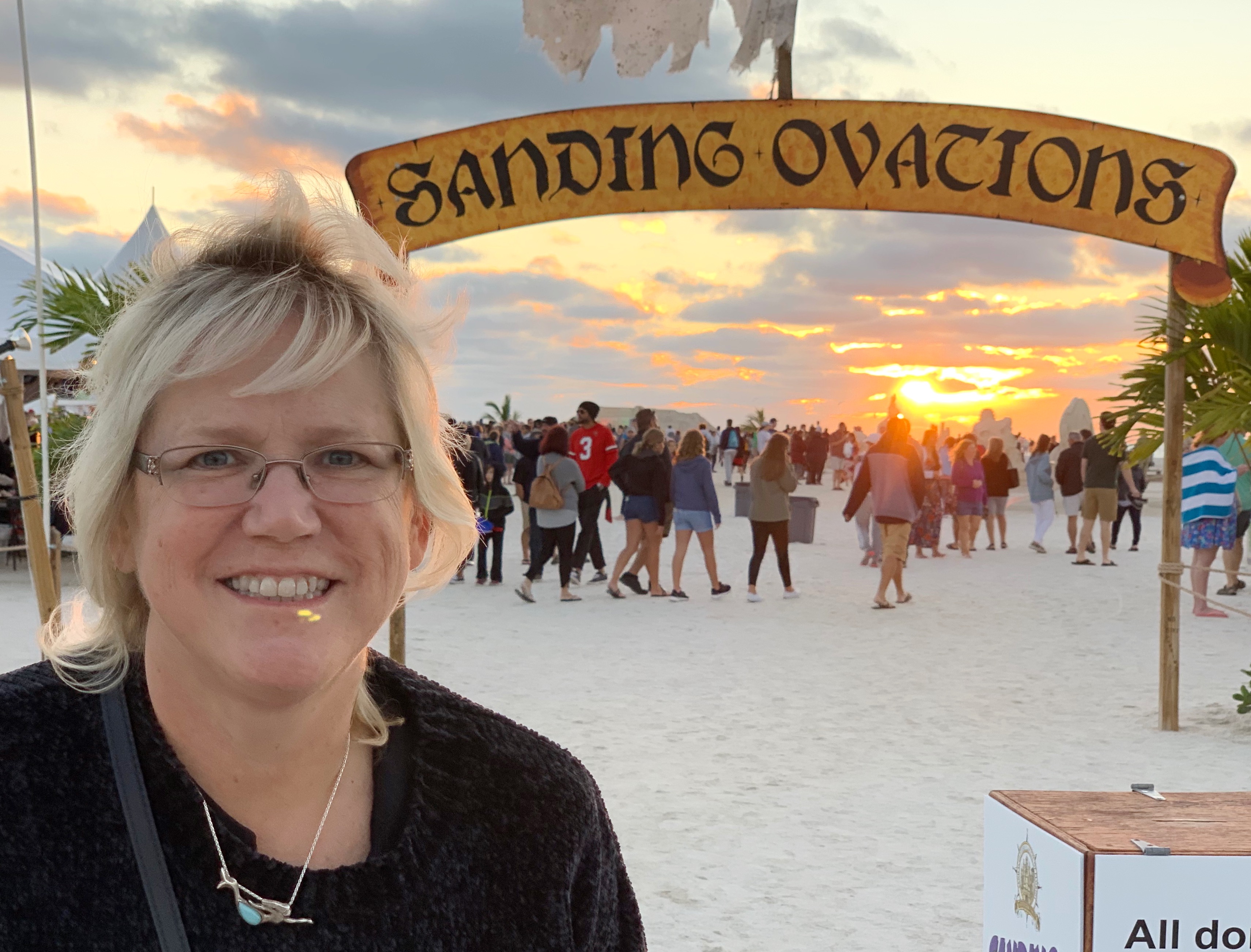 Cyndee Haydon STR specialist Sandbars to Sunsets Team at the Sanding Ovations international sand sculpting competition entrance arch at sunset on Treasure Island Beach Florida Gulf Coast Pinellas County
